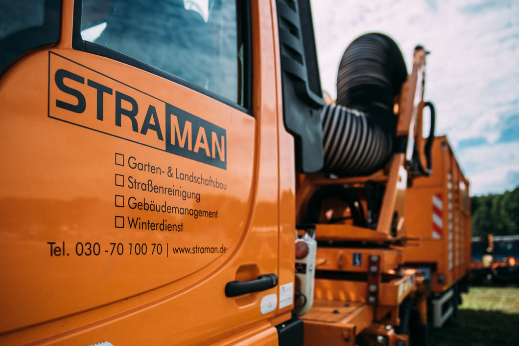 Orangefarbenes STRAMAN Spezialfahrzeug für Garten- und Landschaftsbau, Straßenreinigung, Gebäudemanagement und Winterdienst.