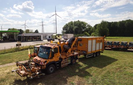 STRAMAN Spezialfahrzeug mit Mähtechnik und großem Sammelanhänger bei der professionellen Grünflächen- und Landschaftspflege.