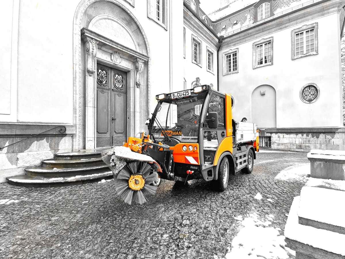 STRAMAN Winterdienstfahrzeug vor historischem Gebäude