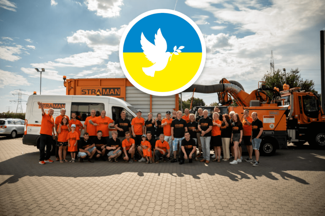 STRAMAN Team vor Firmenfahrzeugen mit blau-gelbem Friedenssymbol als Zeichen der Solidarität mit der Ukraine.